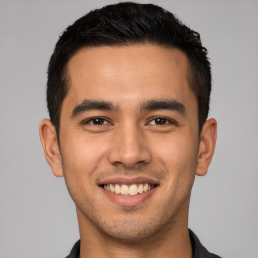 Joyful white young-adult male with short  black hair and brown eyes