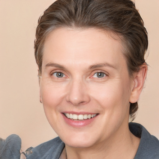 Joyful white adult female with medium  brown hair and grey eyes