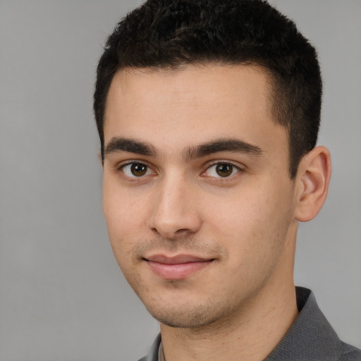 Joyful white young-adult male with short  black hair and brown eyes