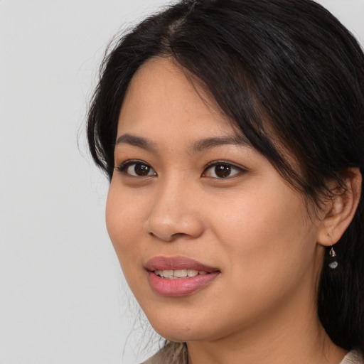Joyful latino young-adult female with medium  brown hair and brown eyes