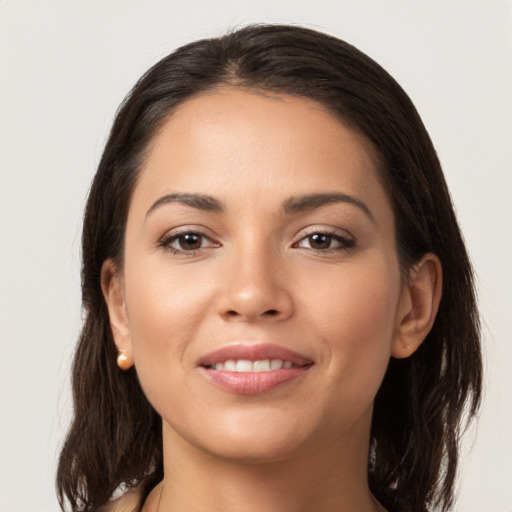 Joyful latino young-adult female with medium  brown hair and brown eyes