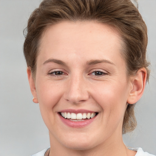 Joyful white young-adult female with short  brown hair and grey eyes