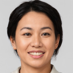 Joyful asian young-adult female with medium  brown hair and brown eyes