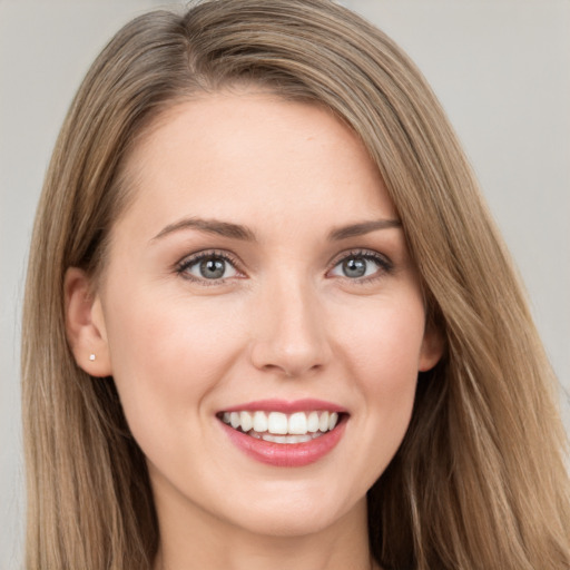 Joyful white young-adult female with long  brown hair and blue eyes