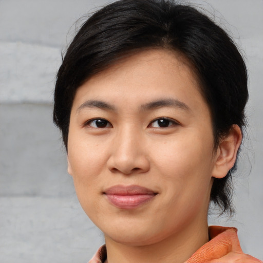 Joyful asian young-adult female with medium  brown hair and brown eyes