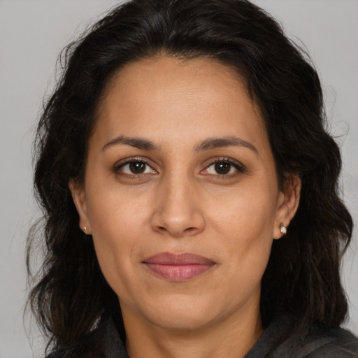 Joyful latino adult female with long  brown hair and brown eyes