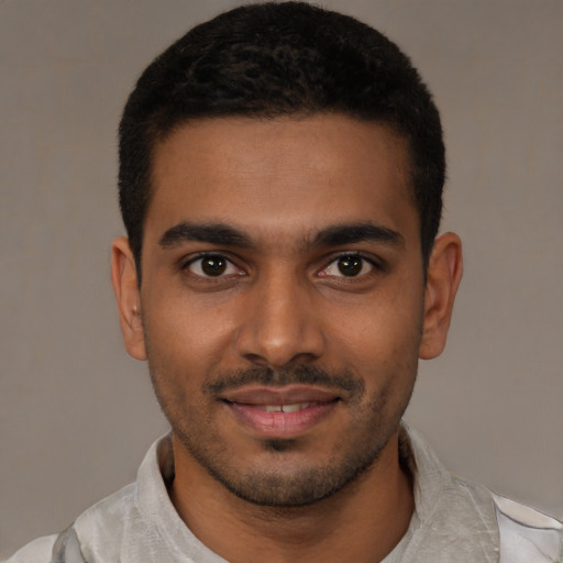 Joyful latino young-adult male with short  brown hair and brown eyes