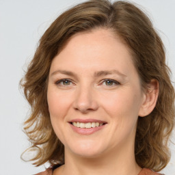 Joyful white young-adult female with medium  brown hair and green eyes