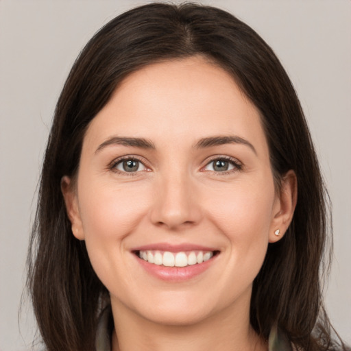 Joyful white young-adult female with long  brown hair and brown eyes