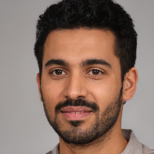 Joyful latino young-adult male with short  black hair and brown eyes