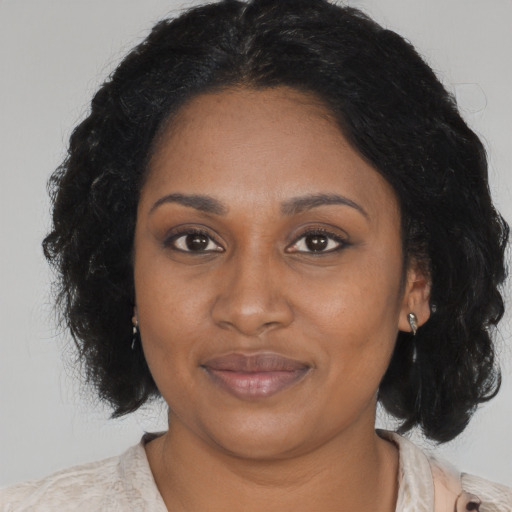 Joyful black adult female with medium  black hair and brown eyes