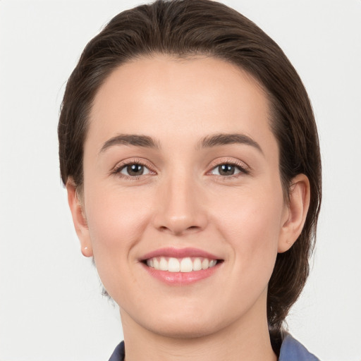 Joyful white young-adult female with medium  brown hair and grey eyes