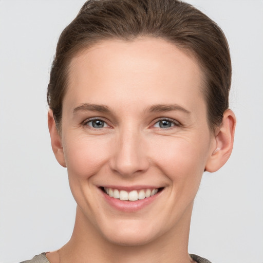 Joyful white young-adult female with short  brown hair and grey eyes