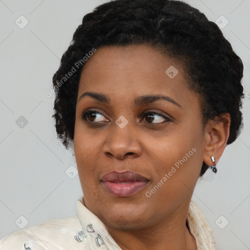 Joyful black young-adult female with short  black hair and brown eyes