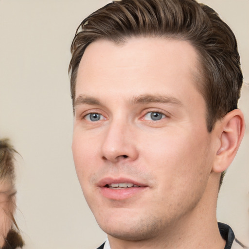 Joyful white young-adult male with short  brown hair and grey eyes