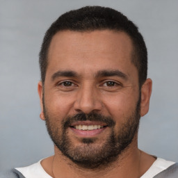 Joyful white young-adult male with short  black hair and brown eyes