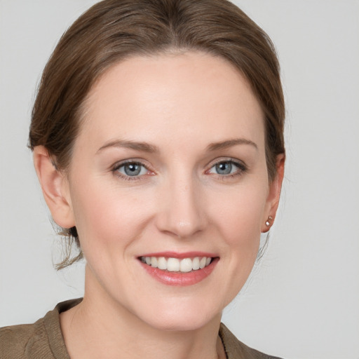 Joyful white young-adult female with medium  brown hair and grey eyes