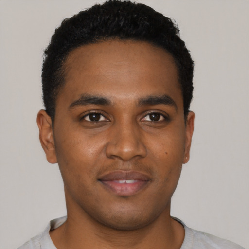 Joyful black young-adult male with short  black hair and brown eyes