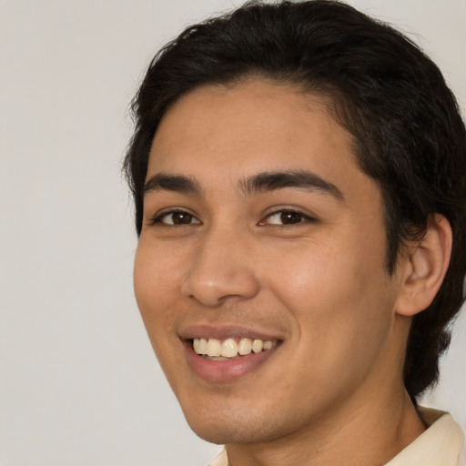 Joyful latino young-adult male with short  brown hair and brown eyes