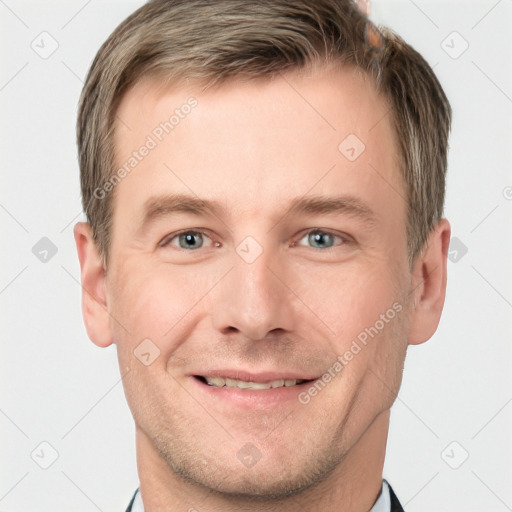 Joyful white young-adult male with short  brown hair and grey eyes