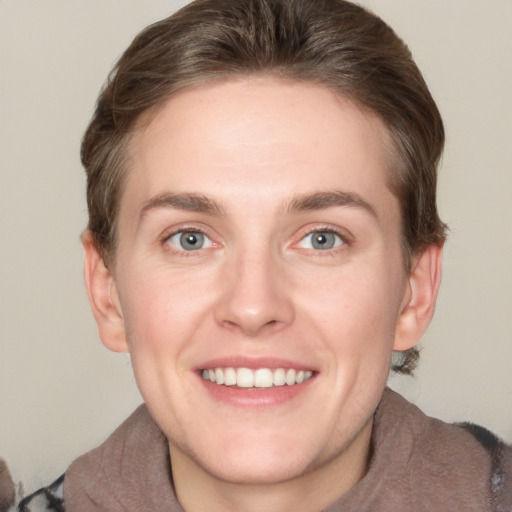 Joyful white young-adult female with short  brown hair and grey eyes