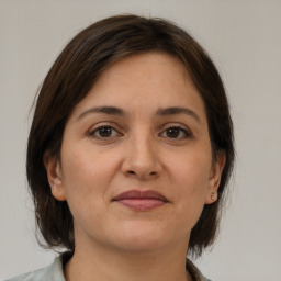 Joyful white adult female with medium  brown hair and brown eyes