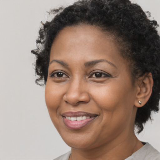 Joyful black adult female with short  brown hair and brown eyes