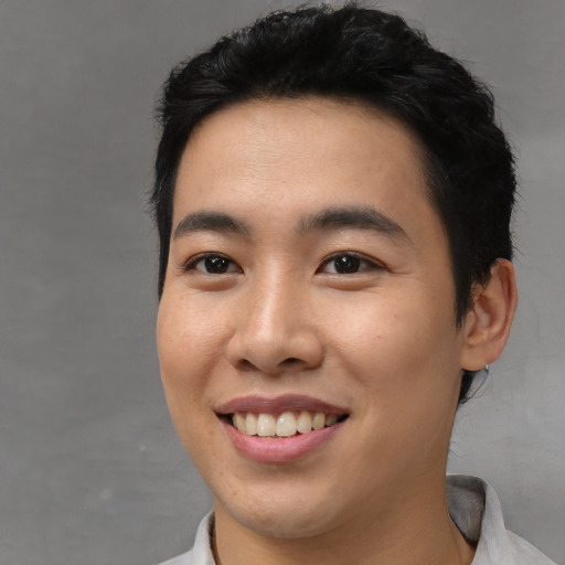 Joyful asian young-adult male with short  black hair and brown eyes