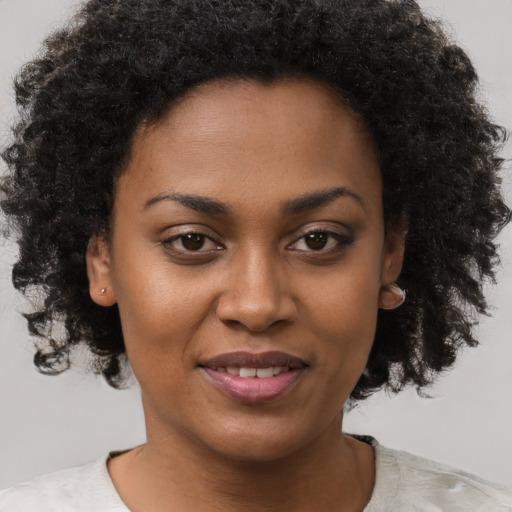 Joyful black young-adult female with short  brown hair and brown eyes