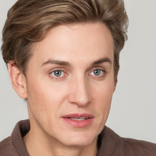 Joyful white young-adult male with short  brown hair and blue eyes