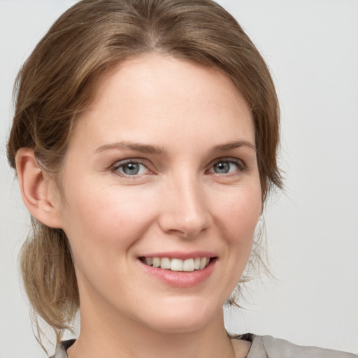 Joyful white young-adult female with medium  brown hair and grey eyes