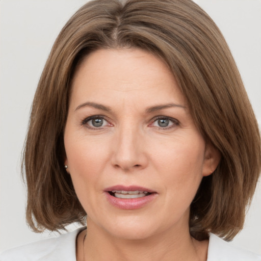 Joyful white adult female with medium  brown hair and brown eyes