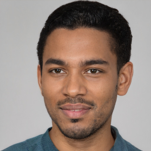 Joyful black young-adult male with short  black hair and brown eyes