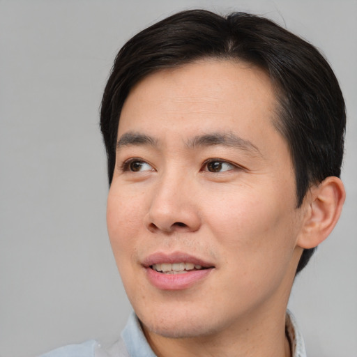 Joyful asian young-adult male with short  brown hair and brown eyes