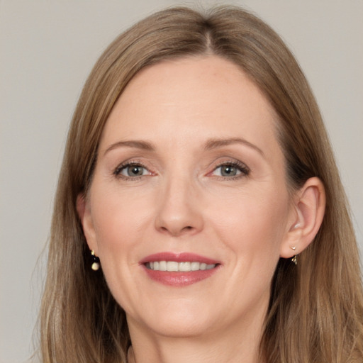 Joyful white adult female with long  brown hair and grey eyes