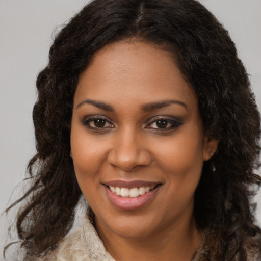 Joyful black young-adult female with long  brown hair and brown eyes