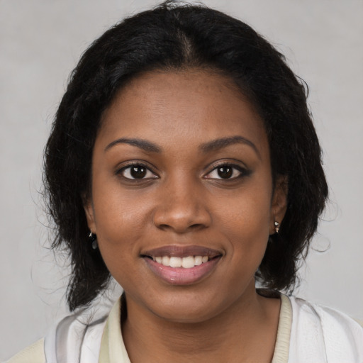 Joyful black young-adult female with medium  brown hair and brown eyes