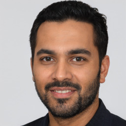Joyful latino young-adult male with short  black hair and brown eyes