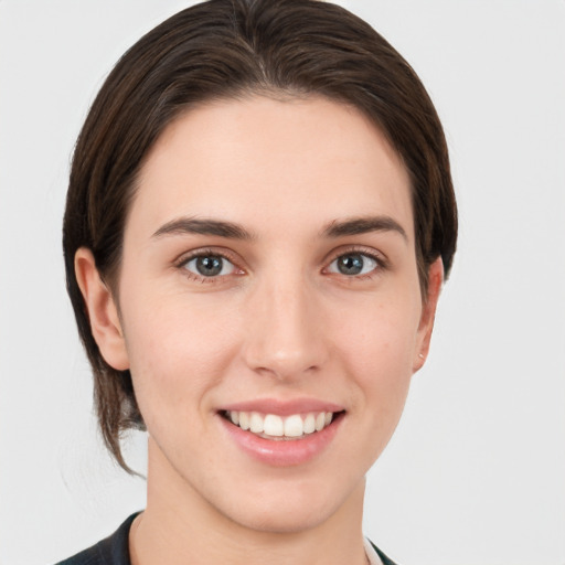 Joyful white young-adult female with short  brown hair and grey eyes