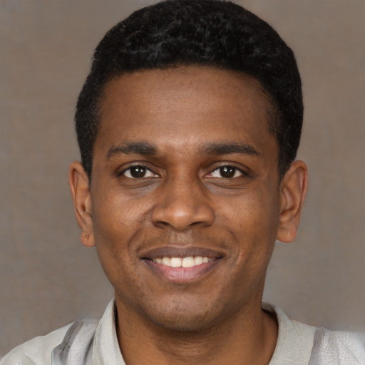 Joyful black young-adult male with short  black hair and brown eyes