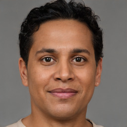 Joyful latino young-adult male with short  brown hair and brown eyes