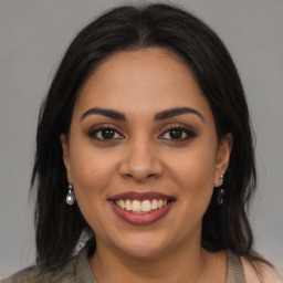 Joyful latino young-adult female with long  brown hair and brown eyes