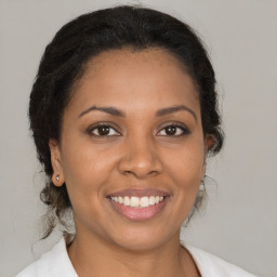 Joyful latino young-adult female with medium  brown hair and brown eyes