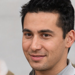 Joyful white young-adult male with short  black hair and brown eyes