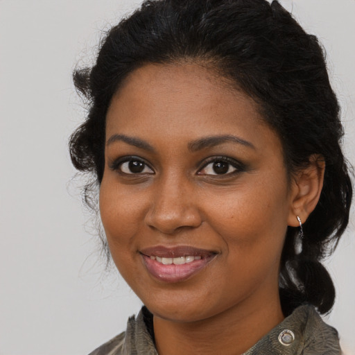 Joyful black young-adult female with medium  brown hair and brown eyes