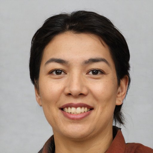 Joyful white adult female with medium  black hair and brown eyes