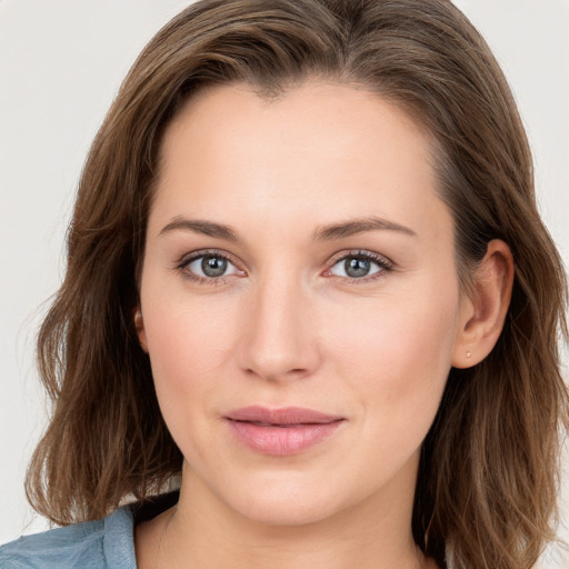 Joyful white young-adult female with long  brown hair and blue eyes