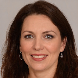 Joyful white adult female with long  brown hair and brown eyes