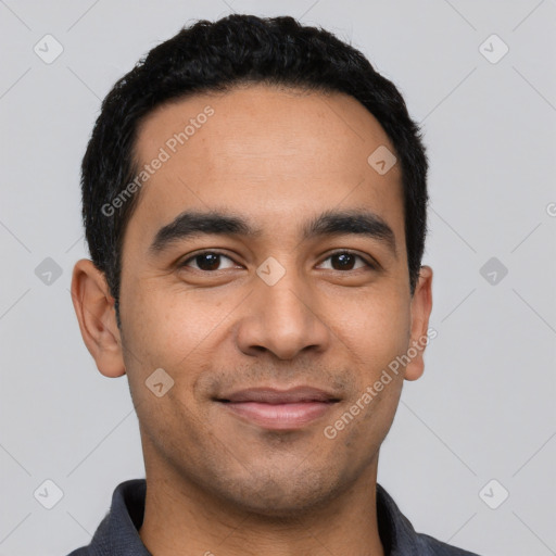 Joyful latino young-adult male with short  black hair and brown eyes