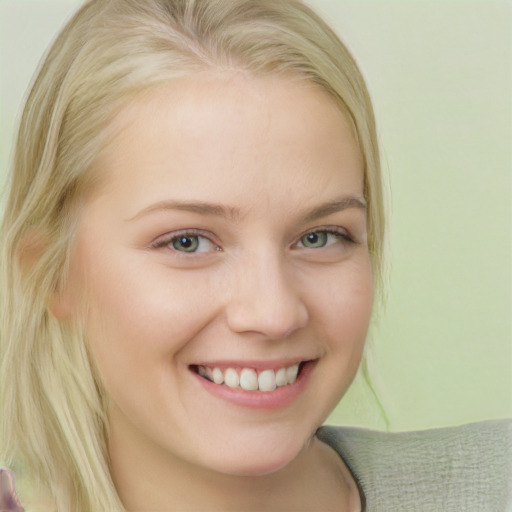 Joyful white young-adult female with long  blond hair and blue eyes